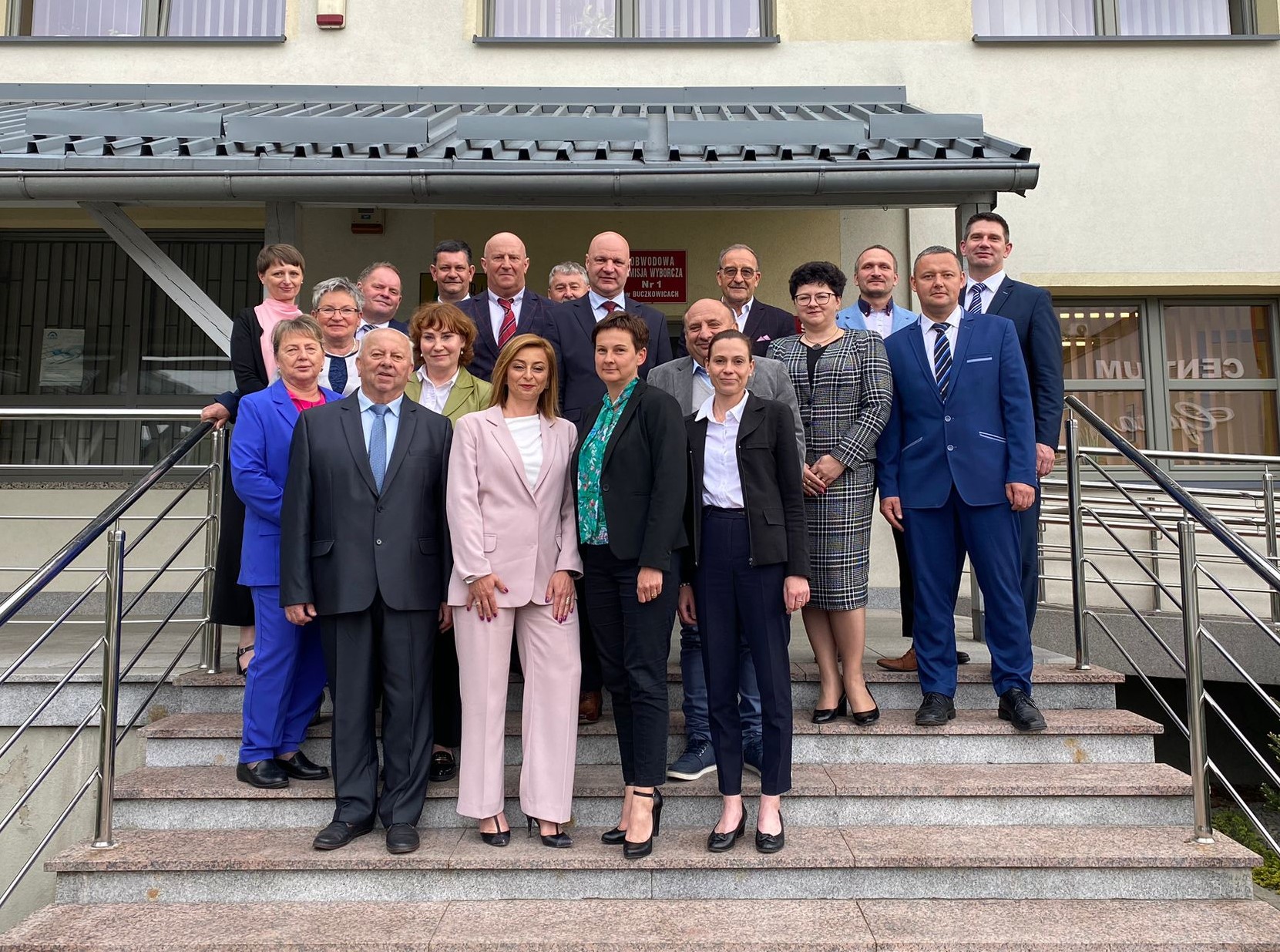 Na schodach przed budynkiem Urzędu Gminy stoją radni z Wójtem Gminy i pracownikami Urzędu obecnymi na I sesji.