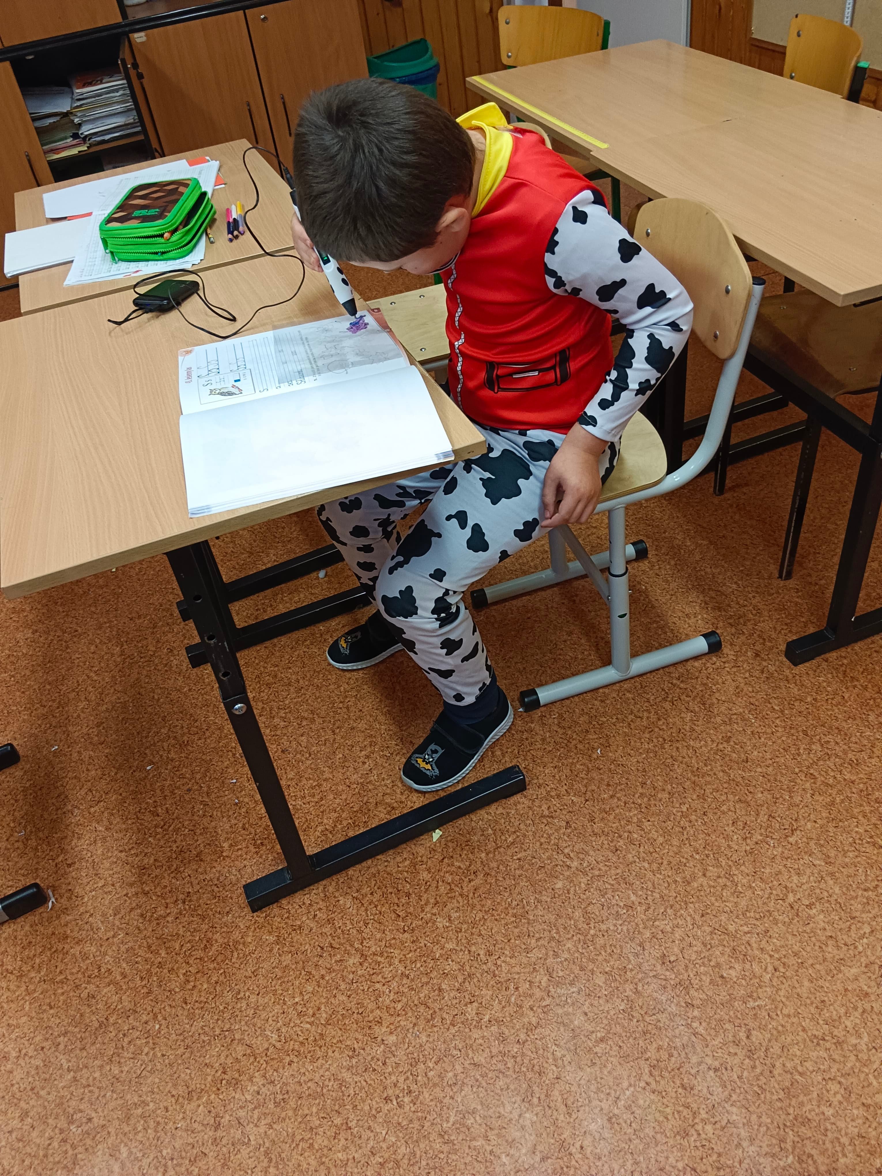 Chłopiec wykonuje rysunek z użyciem długopisu 3D