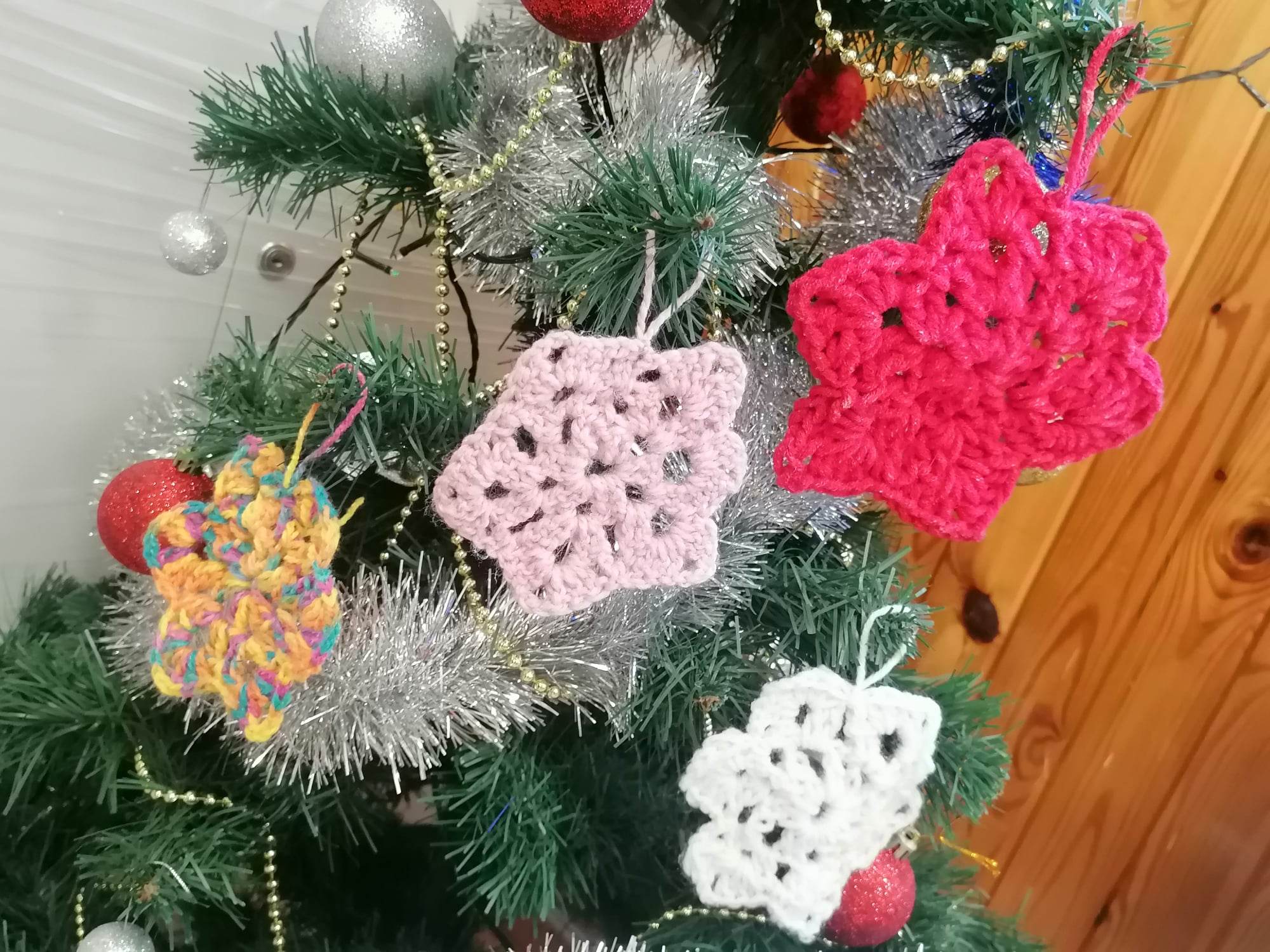 Choinka przyozdobiona w kolorowe bombki z włóczki.