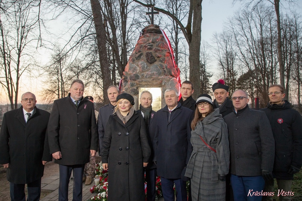 Członkowie delegacji polskiej i łotewskiej pozują przy pomniku