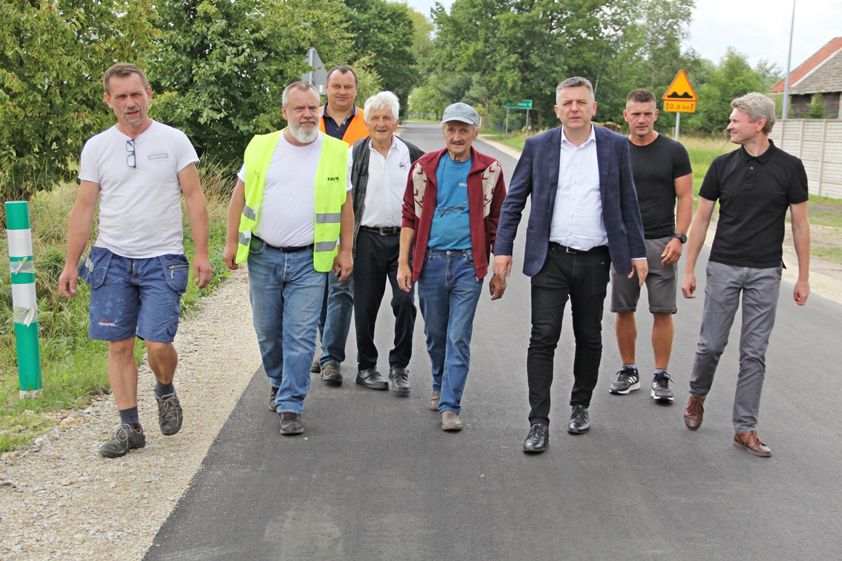 Uczestnicy odbioru technicznego idą wyremontowaną drogą