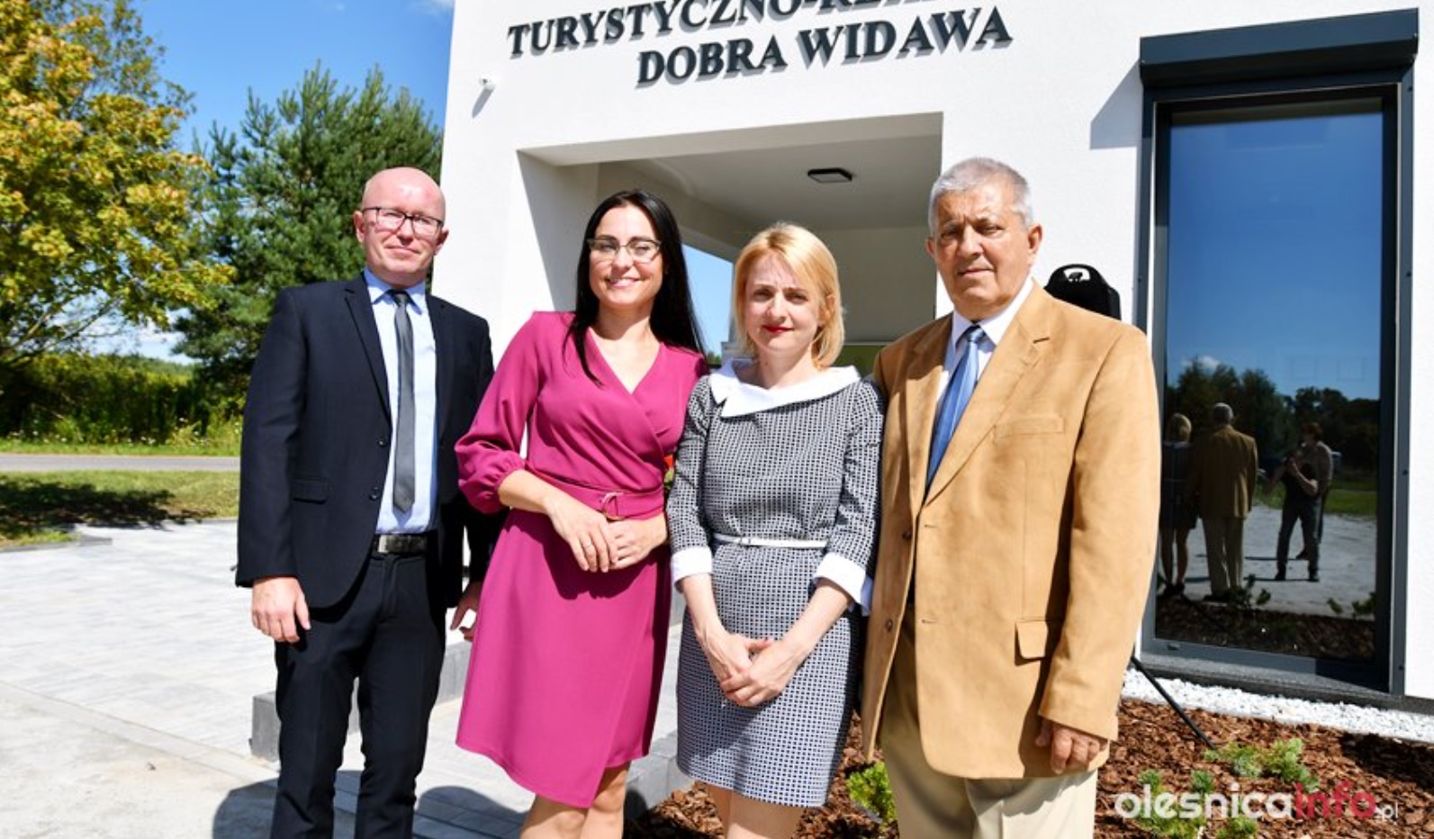 Czworo uczestników wydarzenia stoi na tle budynku Centrum