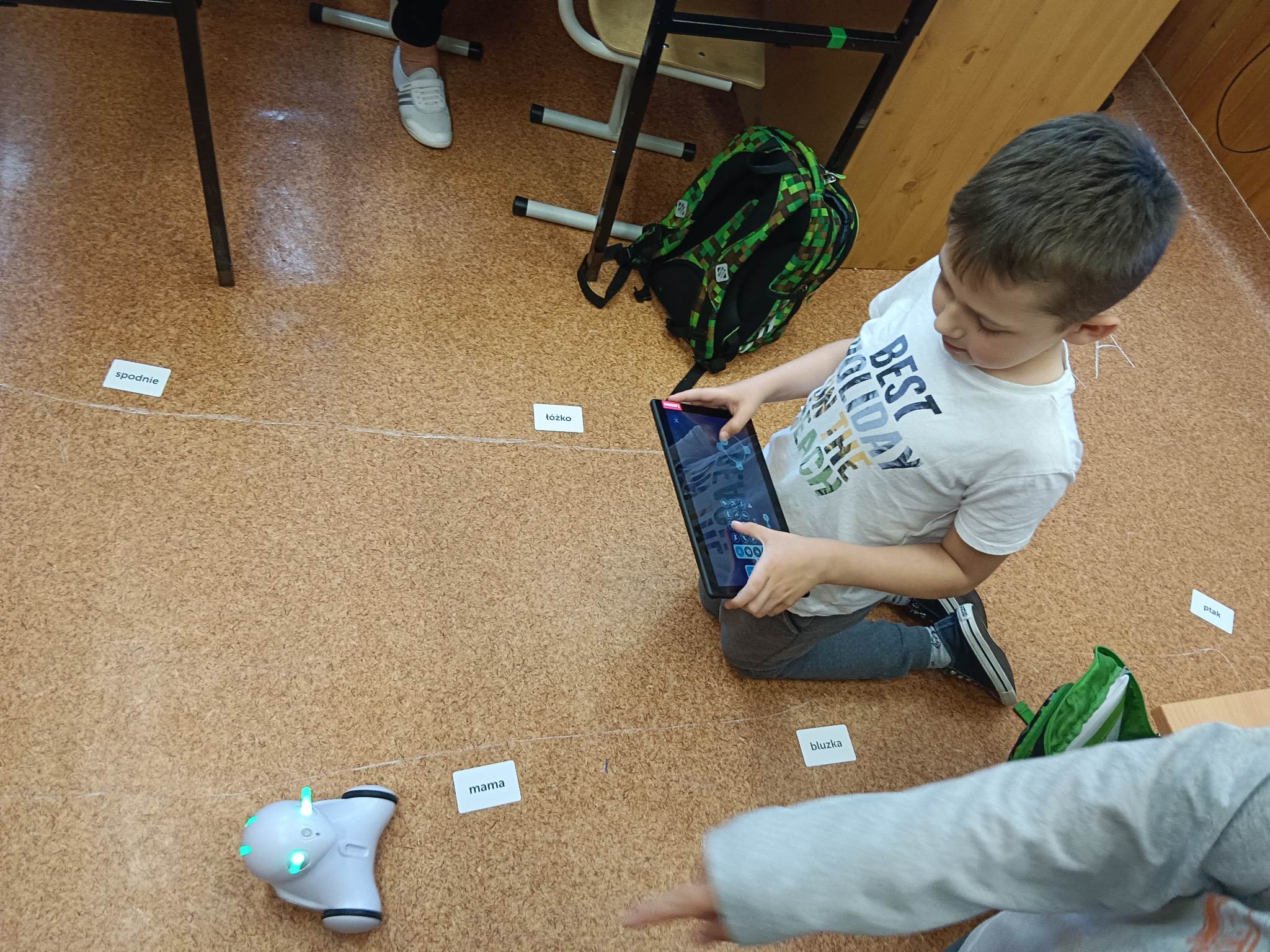 Chłopiec steruje robotem Photon za pomocą tabletu.