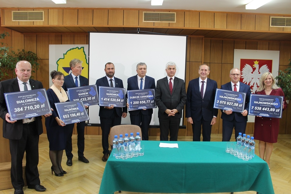 Samorządowcy z Powiatu Hajnowskiego pozują z symbolicznymi promesami