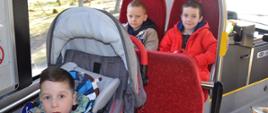 Dzieci siedzą w autokarze, pozują do zdjęcia