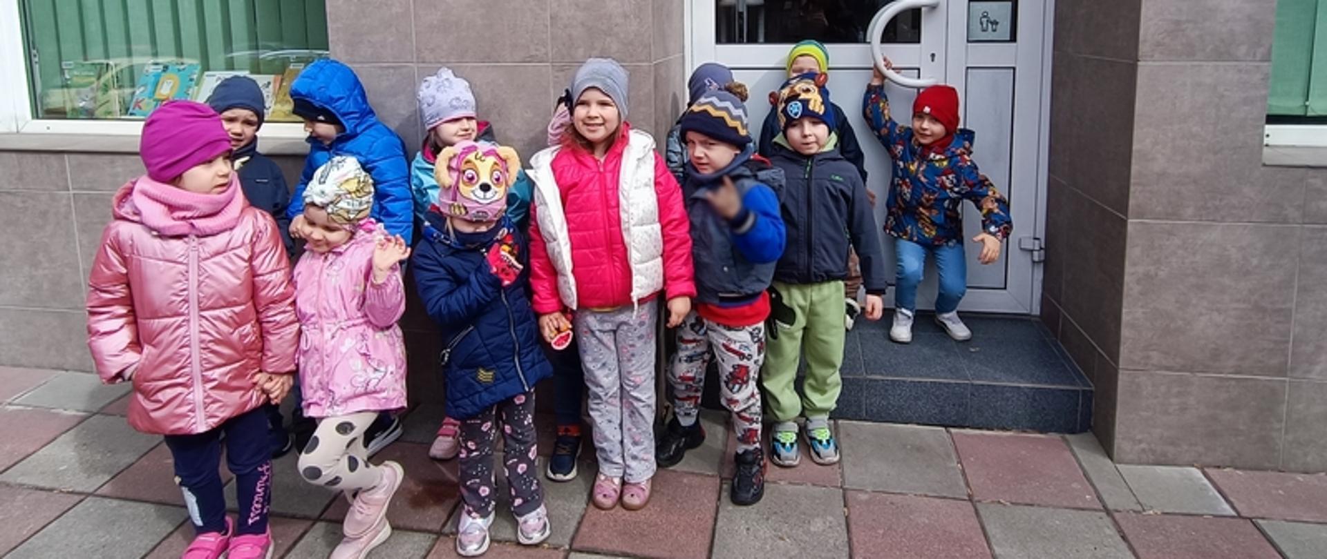 Dzieci pozują przed wejściem do Biblioteki