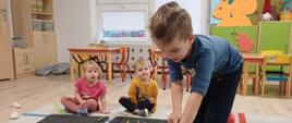 Zajęcia grupowe - chłopczyk bawi się pluszową kostką
