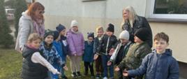Dzieci pozują do zdjęcia przy kwiatach 