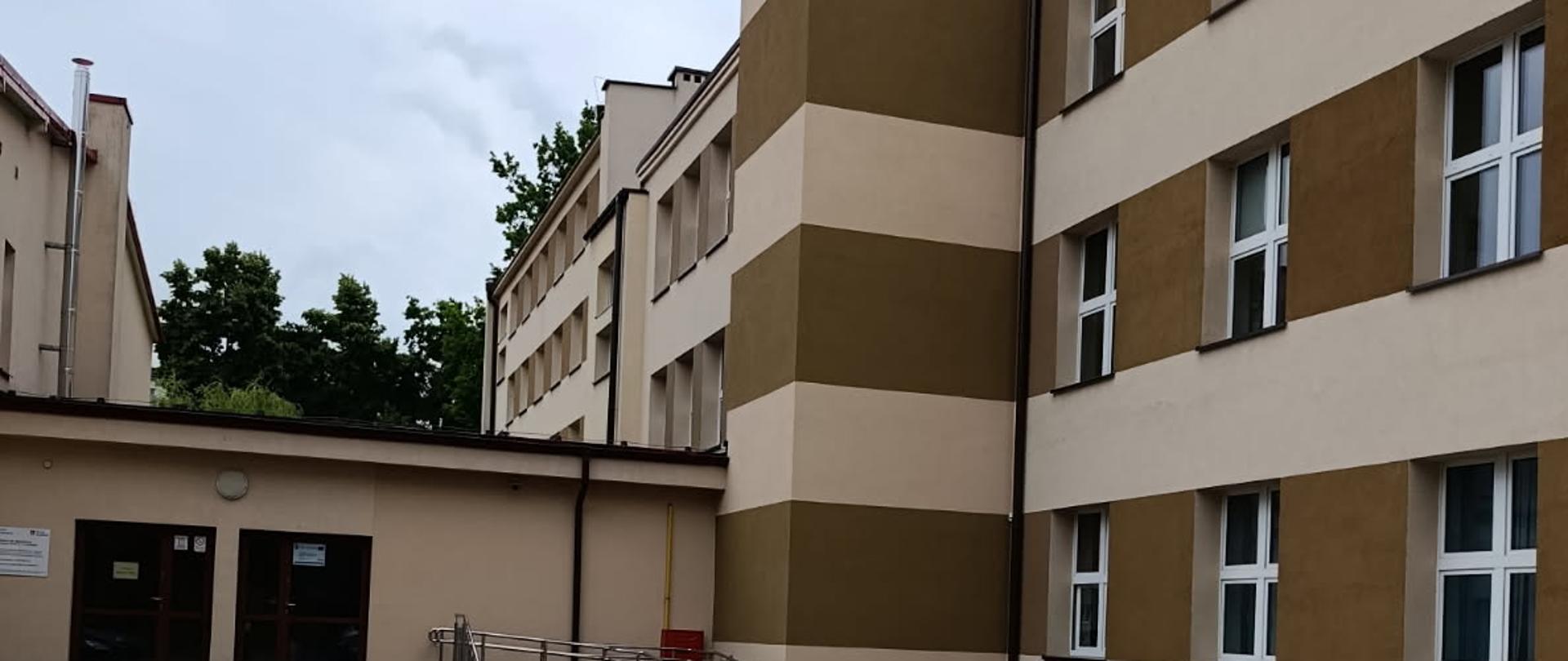 Budynek Zespołu Szkół nr 2 w Kraśniku z widoczną dobudową windy osobowej i placem parkingowym