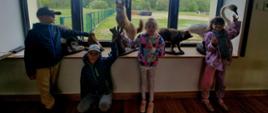 Przedszkolaki pozują do zdjęcia obok ekspozycji zwierząt