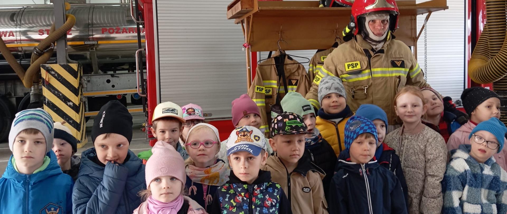Dzieci pozują do zdjęcia ze strażakiem
