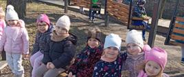 Dzieci pozują do zdjęcia siedząc na ławce