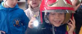 Dzieci przymierzają kaski strażackie