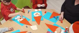 Warsztaty plastyczne - dzieci siedzą przy stole, przygotowują swoje świąteczne kartki