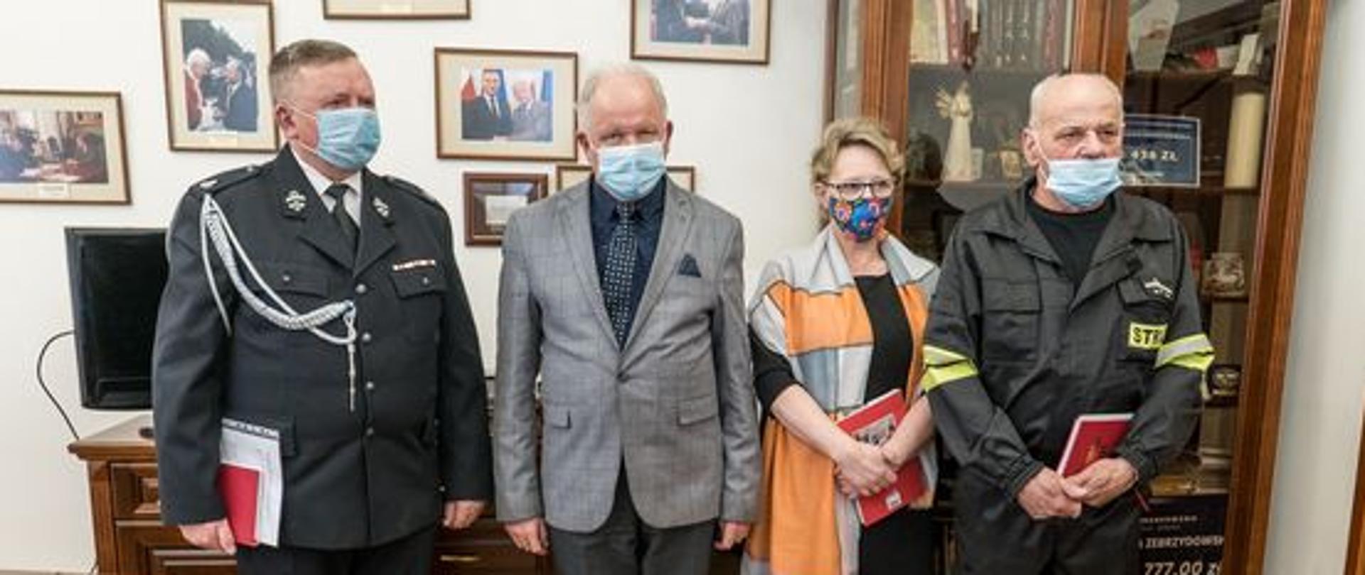 Pozujący do zdjęcia w gabinecie burmistrza, od lewej: Tadeusz Chrostek, Augustyn Ormanty, Zofia Jończyk i Stanisław Brózda. Z tyłu gablota i szafka z telewizorem, na ścianach fotografie w ramkach.