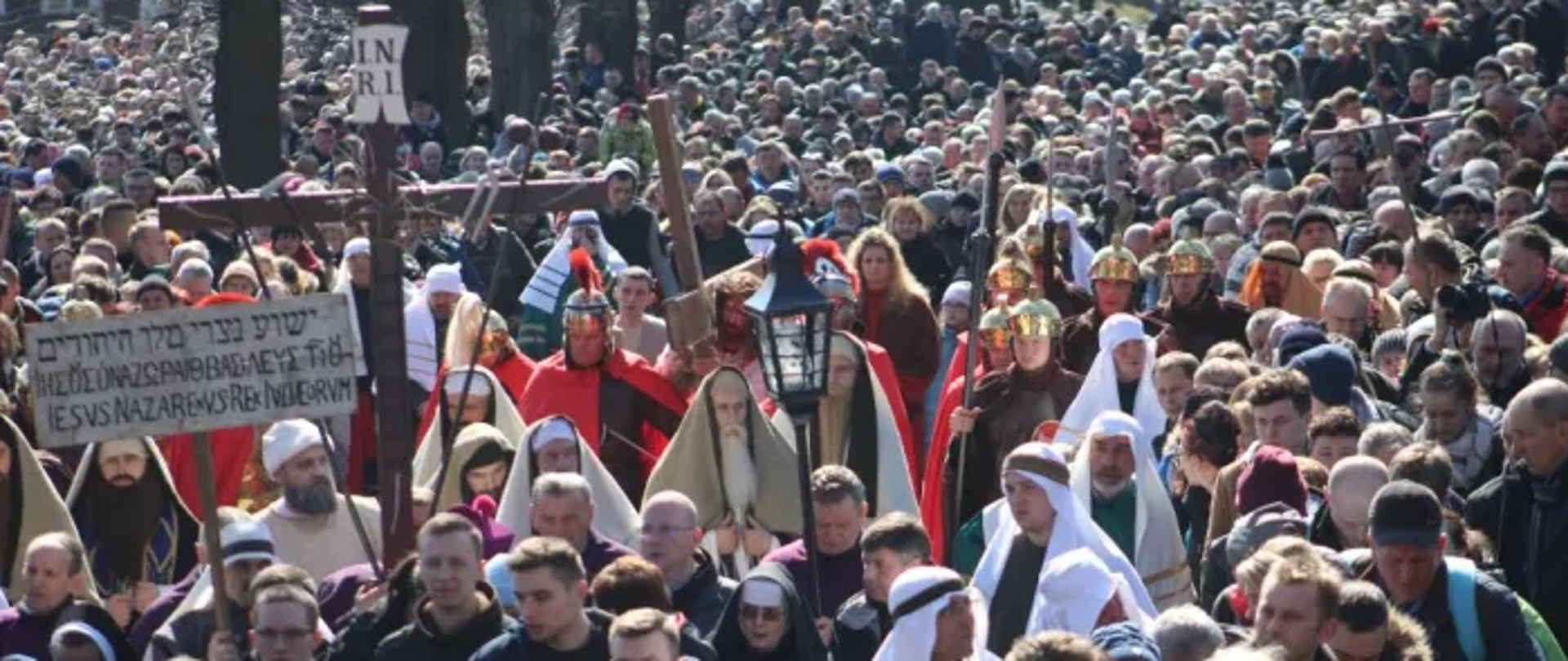 Na zdjęciu wielkopiątkowe Misterium Męki Pańskiej w Kalwarii Zebrzydowskiej. Widoczny tłum ludzi uczestniczących w drodze krzyżowej. W centralnej części widoczny krzyż i postać Pana Jezusa.