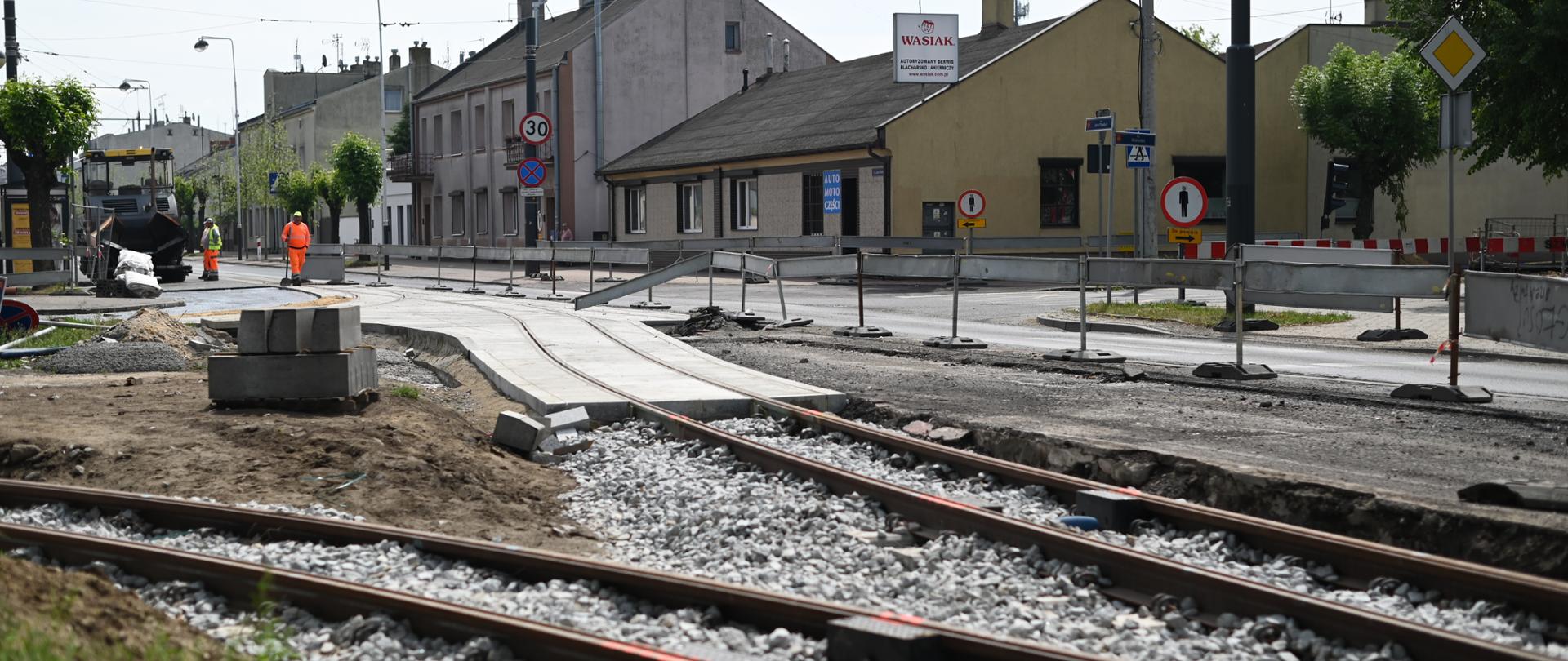 Remont torowiska tramwajowego, w tle robotnicy, koparka, domy przy głównej ulicy w Konstantynowie Łódzkim.