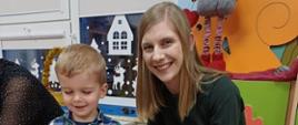 Mama z dzieckiem pozuje do zdjęcia w trakcie zajęć plastycznych