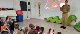 Grupa przedszkolna słucha wykładu strażaka