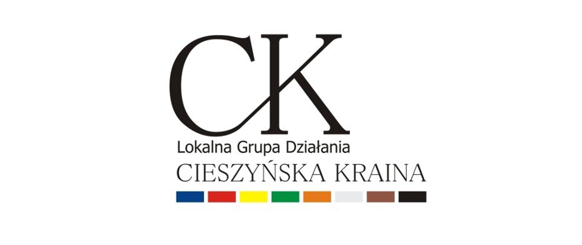 Na białym tle czarne litery CK. Poniżej napis Lokalna Grupa Działania, niżej napis Cieszyńska Kraina. U dołu elementy graficzne w postaci ośmiu różnokolorowych prostokątów.