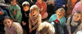 Dzieci siedzą na dywanie