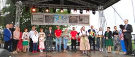 Sołtys Rudnika Urszula Lebioda dziękuje wszystkim osobom, organizacjom i instytucjom, które pomogły we właściwym przygotowaniu obchodów jubileuszu. Na scenie stoi grupa osób. Z tyłu za nim baner z napisem: „500 lat Vivat Rudnik”
