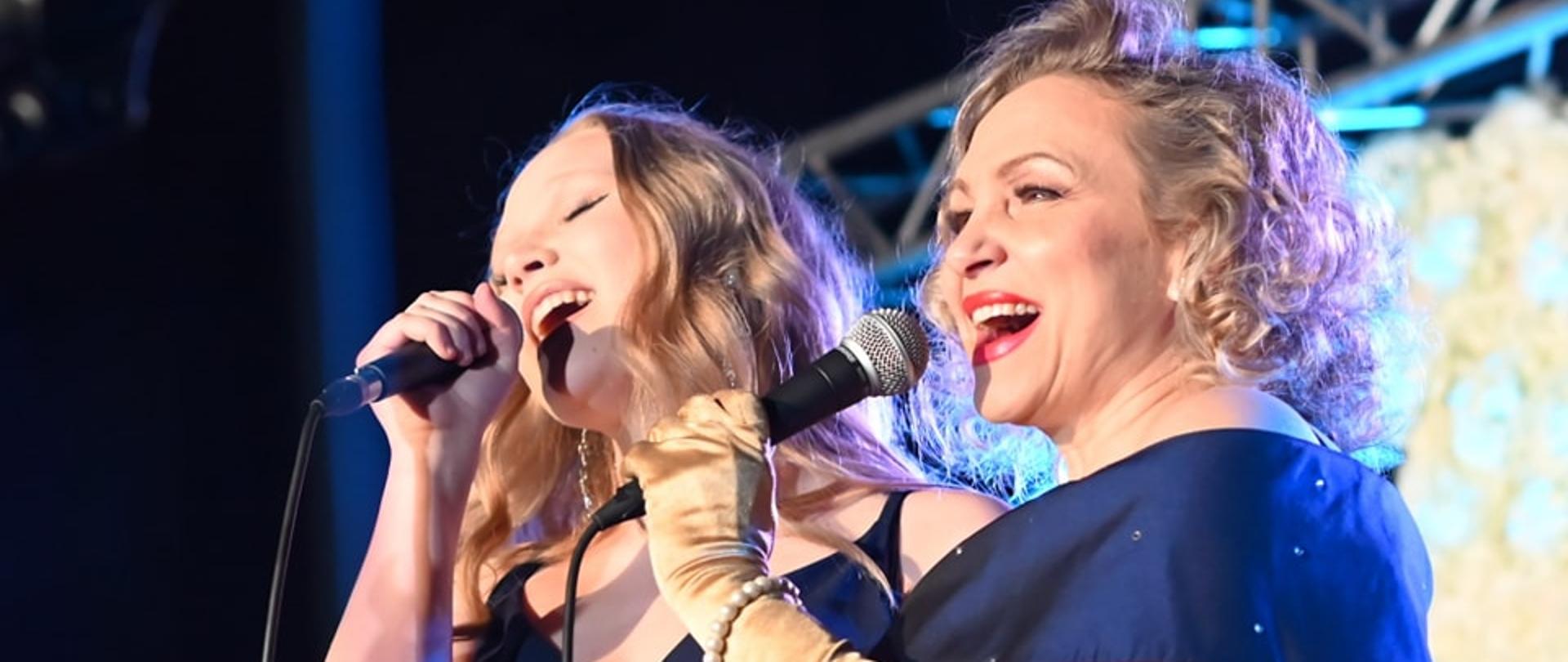 Dwie artystki śpiewają do mikrofonu