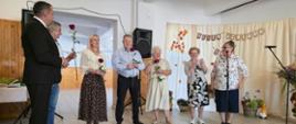 Grupa osób pozuje do wspólnego zdjęcia na tle jesiennej dekoracji.