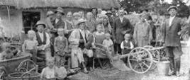 Czarno-biała fotografia na której pozują do zdjęcia dorośli wraz z dziećmi