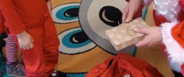 Mikołajki w przedszkolu - Mikołaj rozdaje dzieciom prezenty