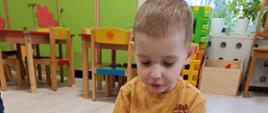 Zabawy - dzieci siedzą w sali, układają puzzle
