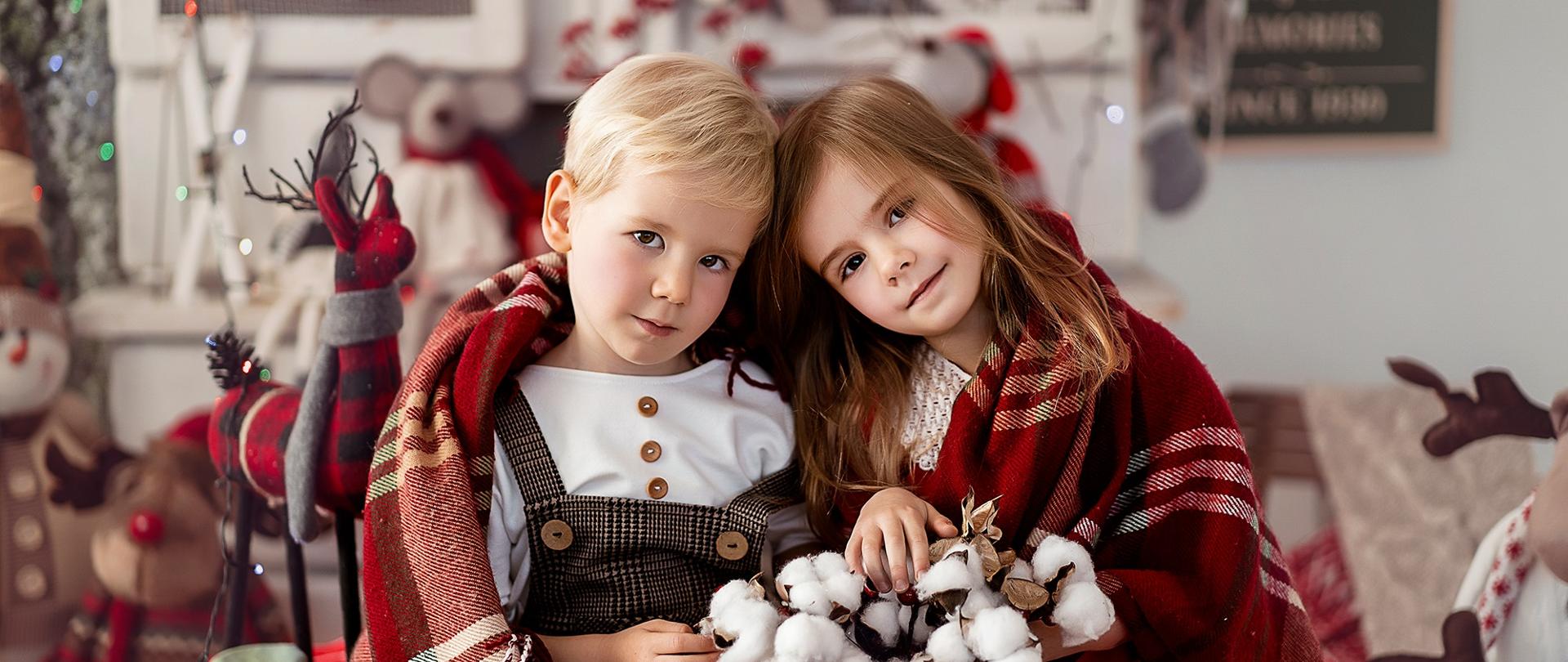 Dwoje dzieci pod kocykiem w świątecznej atmosferze