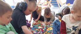Dzieci w trakcie zabawy klockami lego - układają poszczególne elementy, pozują do zdjęć