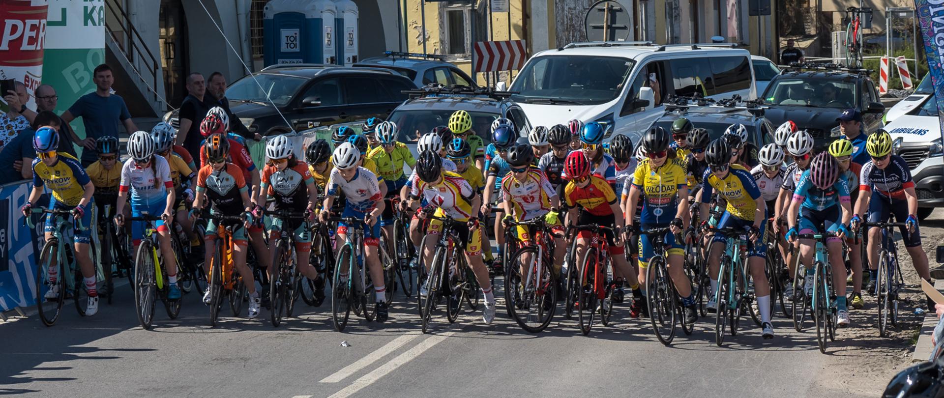 Zdjęcie przedstawia grupę kolarzy na linii startu wyścigu w Urzędowie.