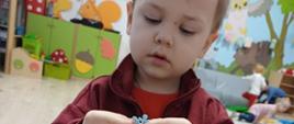 Chłopczyk pozuje do zdjęcia w trakcie zajęć plastycznych