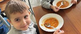 Dwóch chłopców pozuje do zdjęcia w trakcie posiłku
