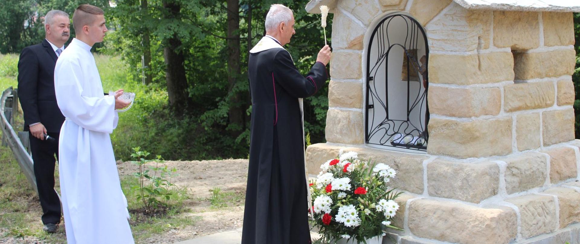 Poświęcenie kapliczki, po prawej odnowiona kapliczka w środku ksiądz po lewej 2 mężczyzn. 