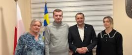 Nauczycielka Urszula Chuda, Paweł Myrda, Wójt Gminy Raba Wyżna Tomasz Rajca oraz mama chłopaka Pani Danuta - pozują do zdjęcia przy fladze Unii Europejskiej oraz Fladze Polski w gabinecie wójta.