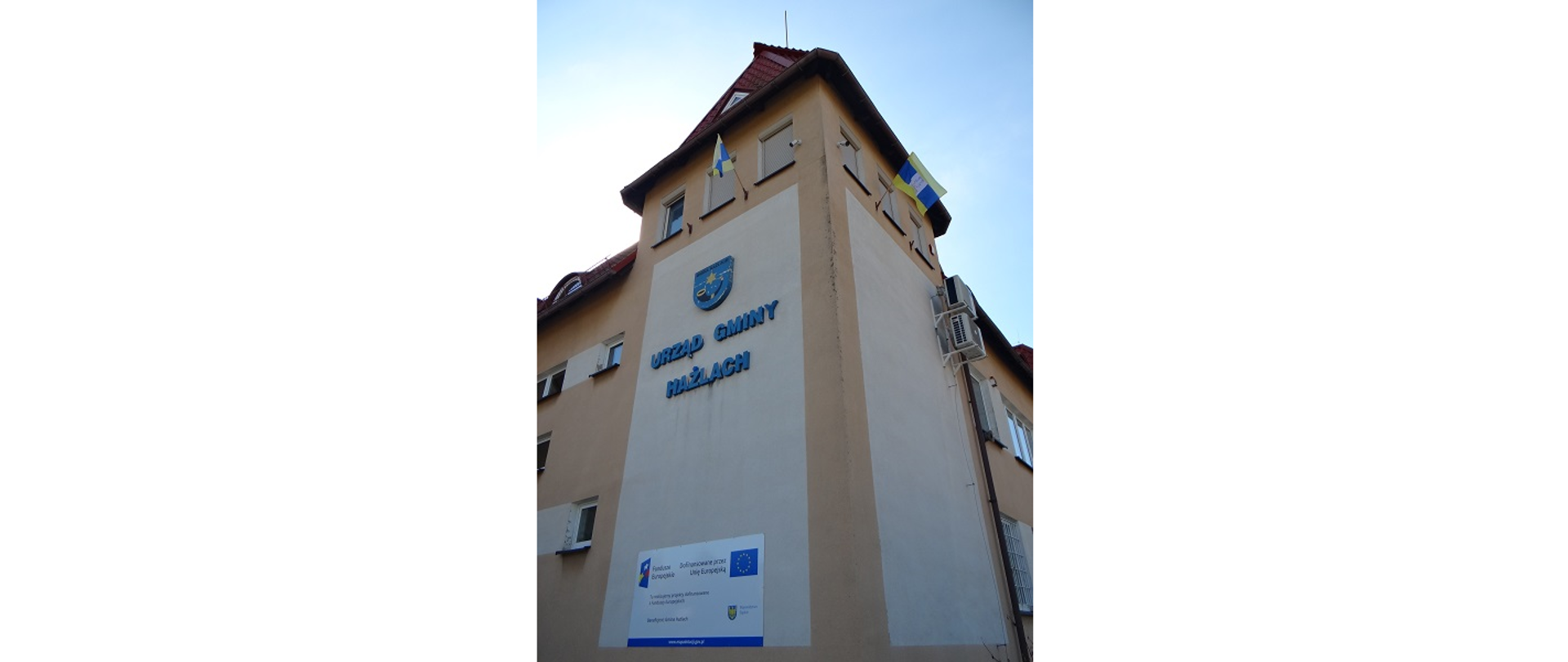 Flagi Euroregionu Śląsk Cieszyński na budynku Urzędu Gminy Hażlach. Powiewają dwie flagi w barwach Euroregionu. Jedna na ścianie od strony północnej, druga na ścianie od strony zachodniej