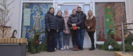 Rada rodziców pozuje do zdjęcia przed wejściem do przedszkola