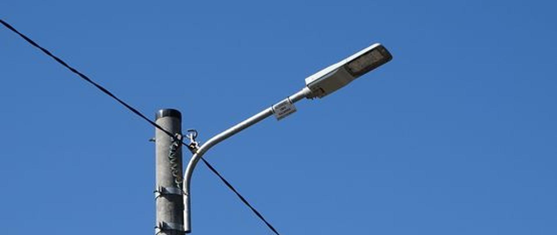 Zdjęcie słupa wraz z lampa ledową na tle niebieskiego nieba