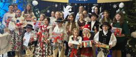 Grupa laureatów wraz z opiekunami na scenie po odbiorze upominków. Dzieci ubrane w góralskie stroje.