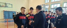 Moment wręczenia pucharów z rąk wójta na ręce przedstawicieli młodzieżowych drużyn pożarniczych.