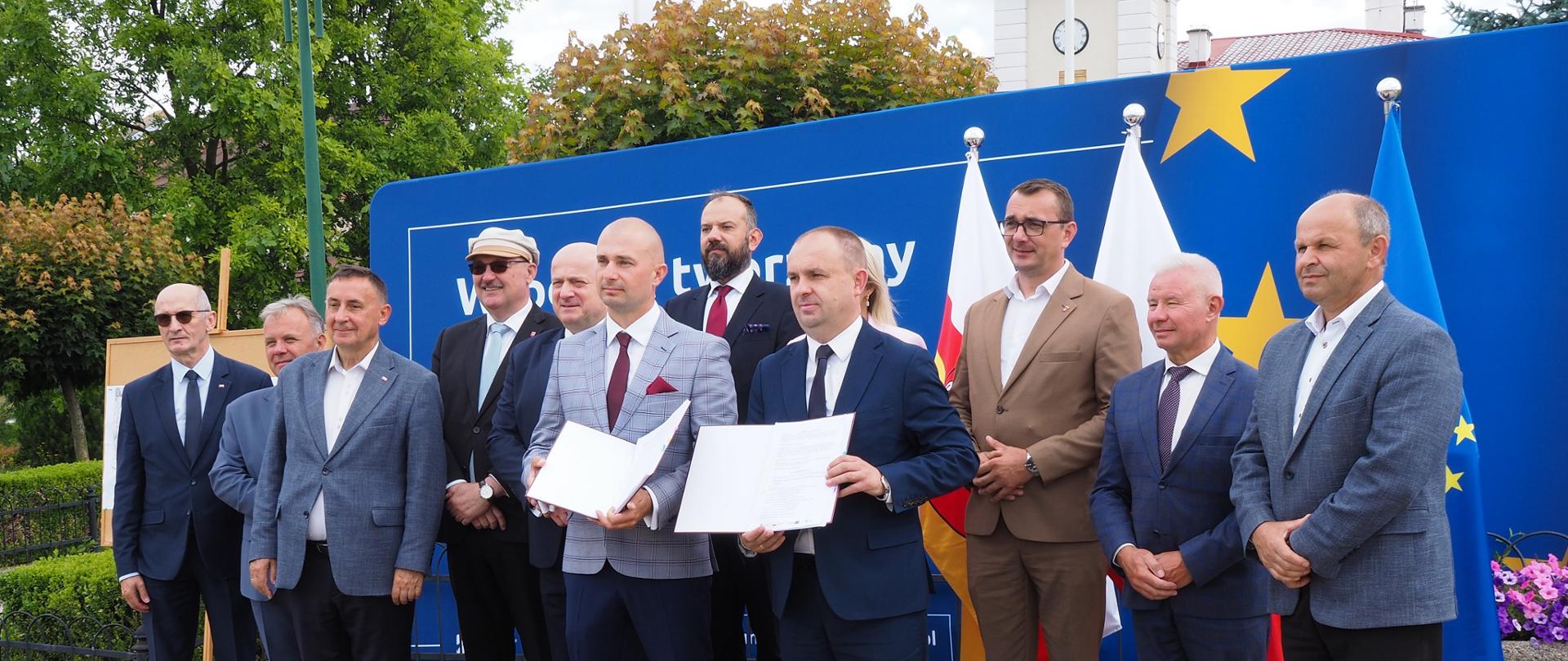 Na zdjęciu znajdują się osoby które podpisały umowę i zaproszeni goście na tle ścianki Funduszy Europejskich 