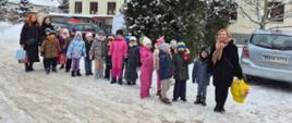 Dzieci pozują do zdjęcia przed budynkiem Domu Opieki