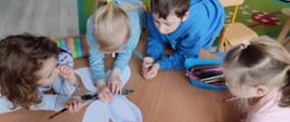 Dzieci kolorują papierowego motyla