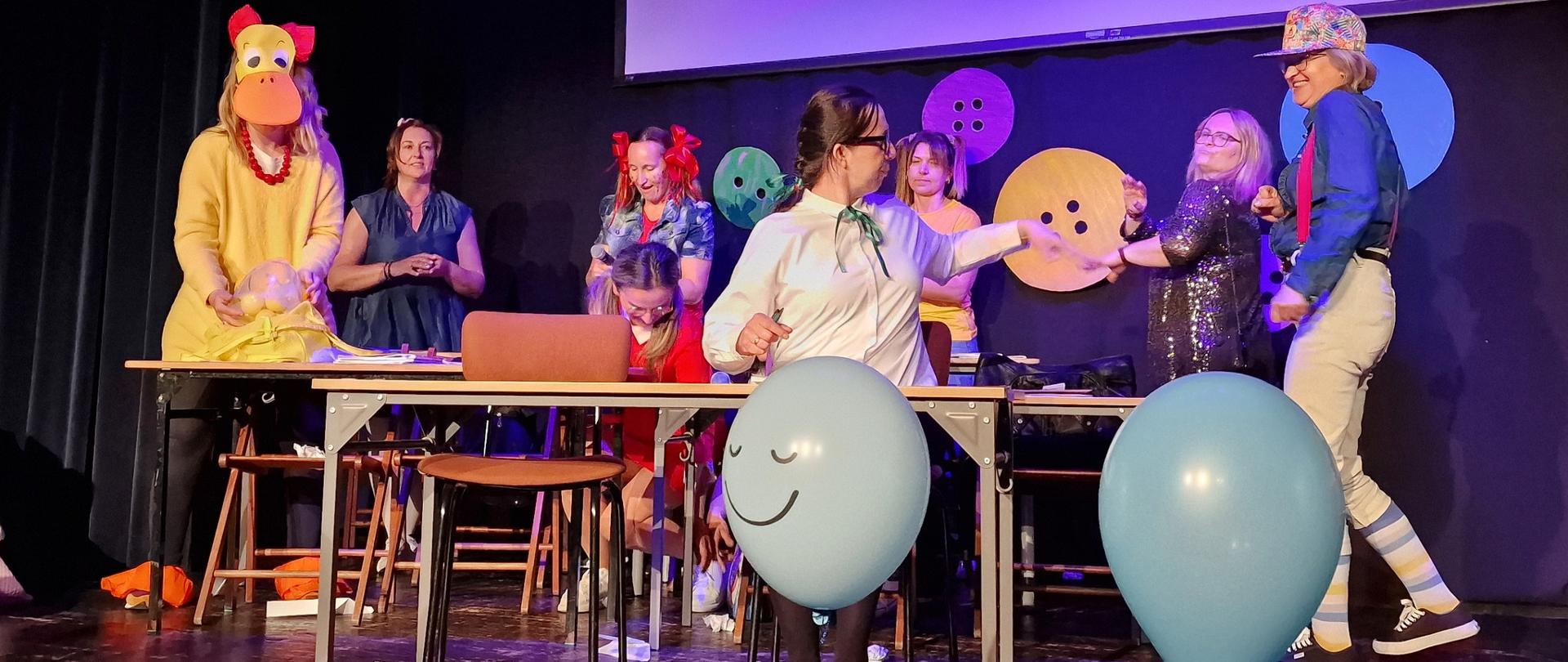 Dorosłe dzieci w przedstawieniu kaczka dziwaczka. Kobiety , nauczycielki przebrane są za uczniów, jedna z nich za kaczkę dziwaczkę.