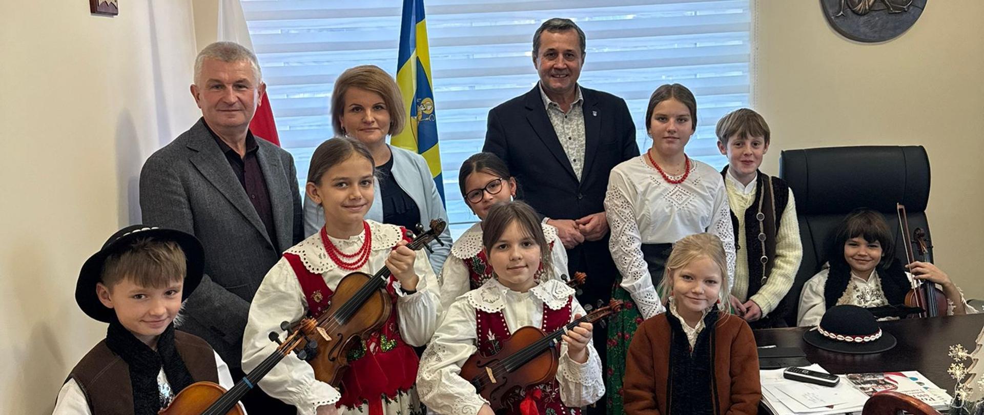 Z Przytupem. Kolędnicy w stroju góralskim ze skrzypcami.