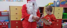 Człowiek przebrany za świętego Mikołaja wręcza dzieciom prezenty