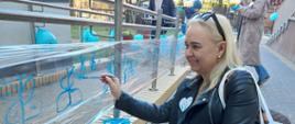 Wspólne malowanie niebieskich kwiatów na folii okalającej wejście budynku